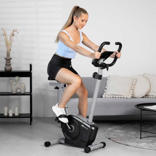 Woman cycling on a Hop-Sport upright exercise bike during a cardio session at home