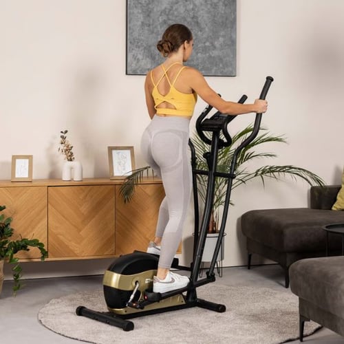 Woman exercising on a Hop-Sport cross trainer, targeting legs, glutes, core, and upper body muscles at home