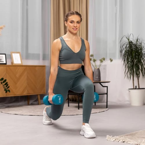 Woman performing forward lunges with dumbbells to build lower body strength and power