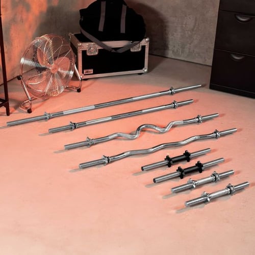 Set of straight and curl barbells with dumbbell bars arranged on gym floor