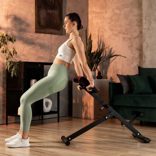 Woman performing back extension on a Hop-Sport Roman chair in a home gym