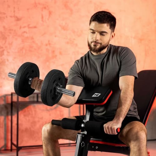 a man seated on a bench doing a dumbbell curl