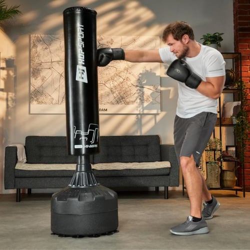 Man practices straight punch on Hop-Sport standing punching bag in living room
