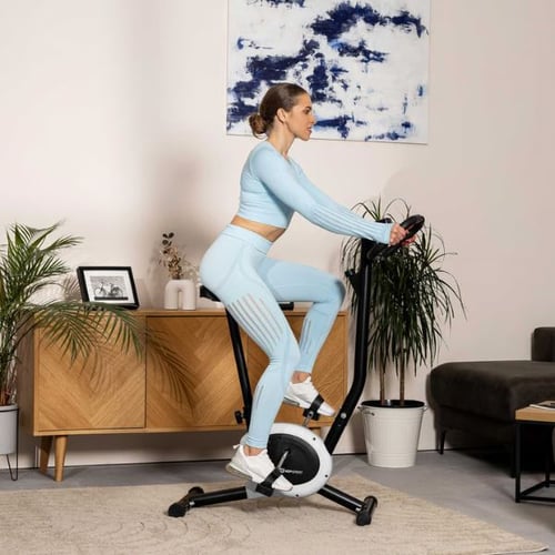 woman pedaling Hop-Sport exercise bike at home, demonstrating lower body muscles worked