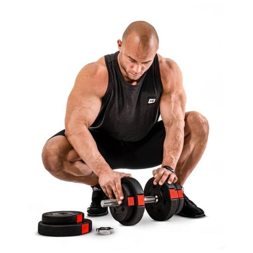 Man squatting while assembling Hop-Sport adjustable dumbbells with weight plates