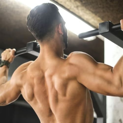 Man doing a pull up showing back muscle engagement on a mounted pull-up bar