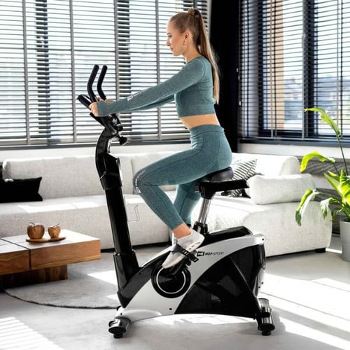 Woman using a Hop-Sport ergometer for endurance training at home to support weight reduction