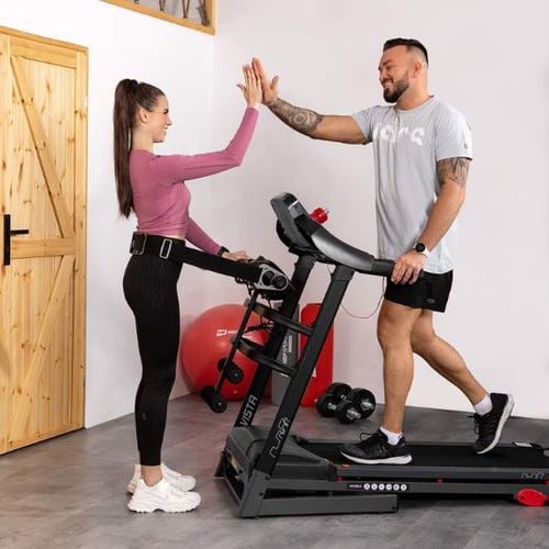 Man and woman high-fiving on a Hop-Sport treadmill after a cardio session