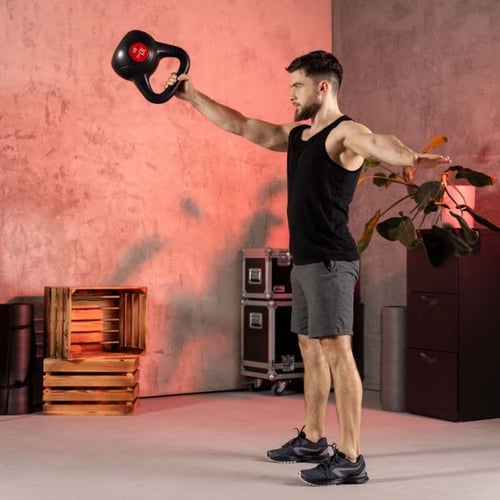 Man holding a Hop-Sport kettlebell on his shoulder while standing, showing grip and control technique