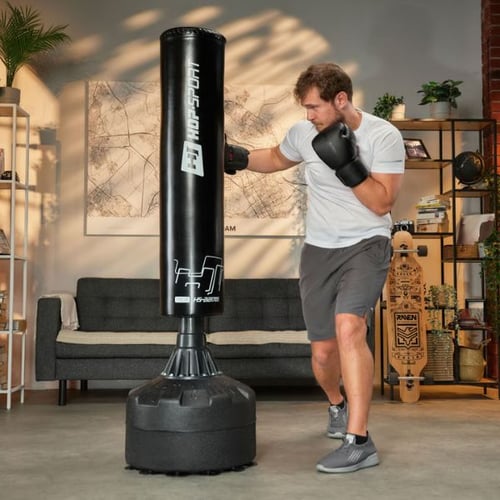 Man in boxing gloves punching a Hop-Sport free-standing punching bag in a home gym