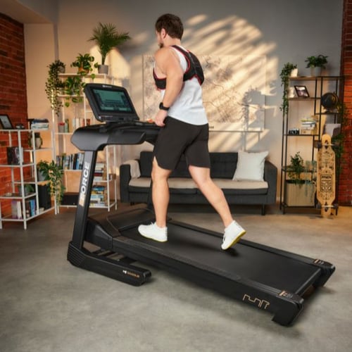 Man walking on a treadmill while wearing a Hop-Sport weighted vest