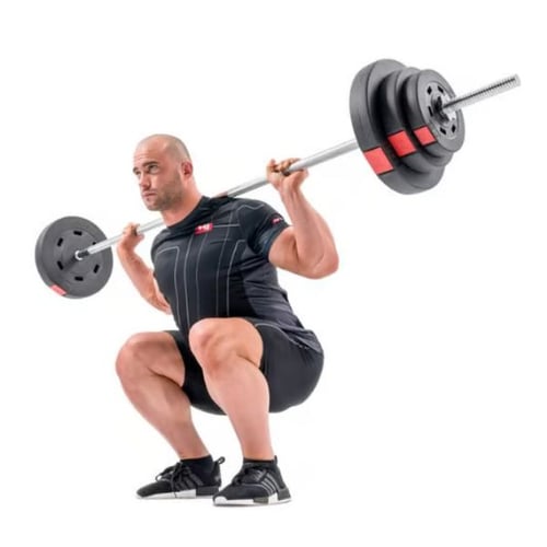 Man squatting deeply with a loaded Hop-Sport barbell, demonstrating correct squat form