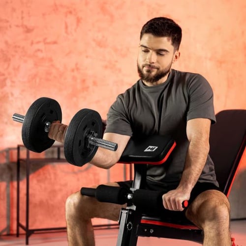 Man performing seated bicep curls on a Hop-Sport bench using adjustable dumbbells