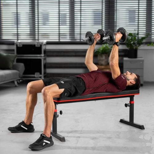 Man doing a dumbbell bench press on a Hop-Sport flat weight bench in a home gym