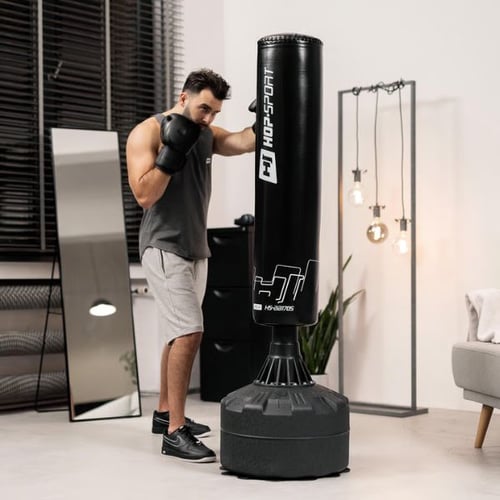 Man in boxing stance training with a Hop-Sport punching bag indoors