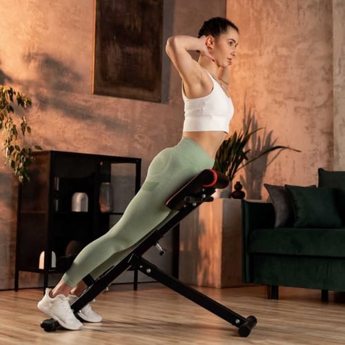 Woman performing lower back extension on incline Roman bench at home gym