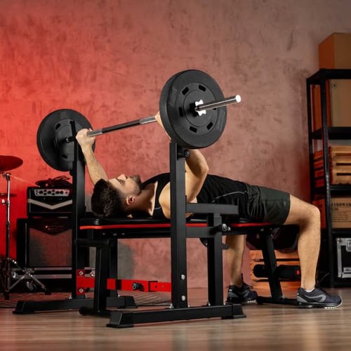 Man performing bench press with Hop-Sport barbell on weight bench, building muscle to support fat burning