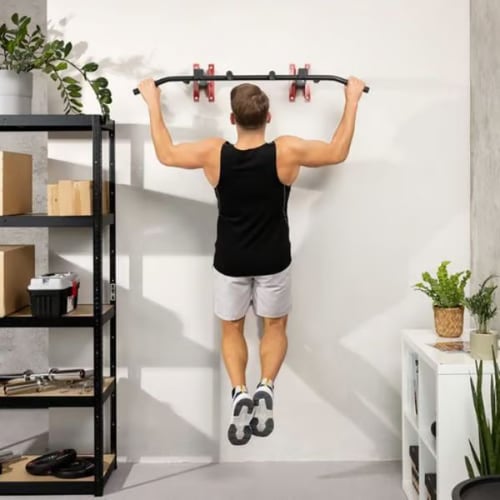 Man performing pull up at home using a wall-mounted Hop-Sport pull-up bar